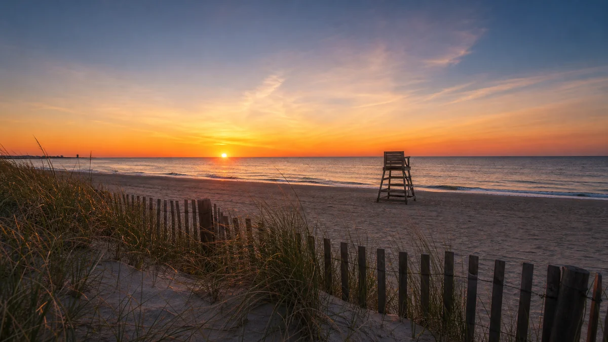 Long Beach Island shoreline at sunset with a weathered dune fence in the foreground