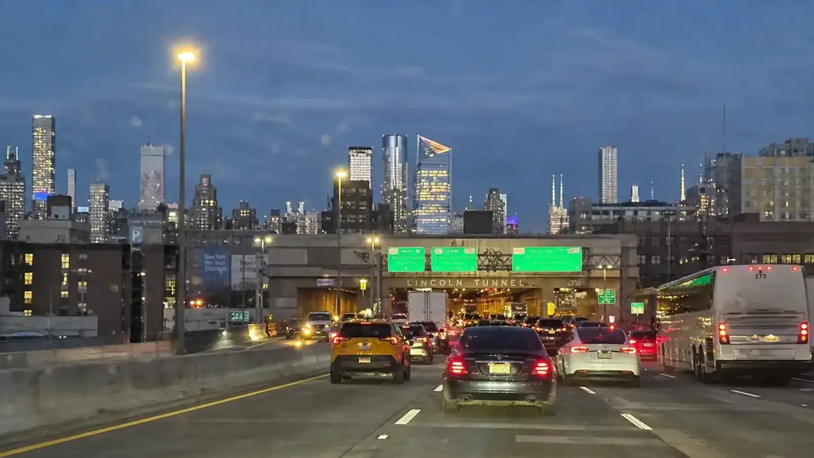 Manhattan skyline view from a vehicle approaching the Lincoln Tunnel from New Jersey at dusk